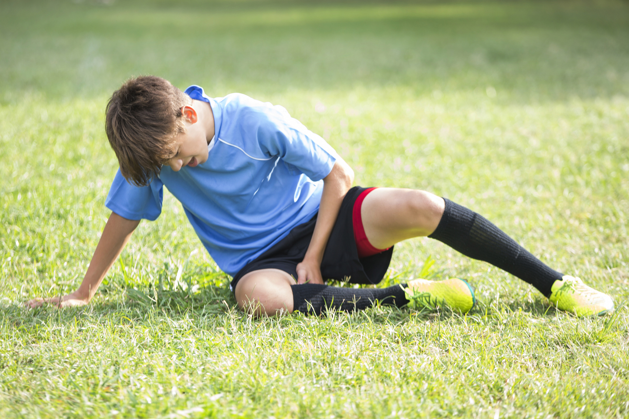 Boy pain. Спорт. Спортивный травматизм у детей. Мальчик в шортах футболист. Травмы в детском спорте.
