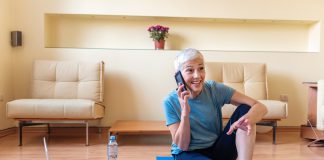 Senior woman using smartphone at home after exercise