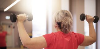 Woman doing dumbbell chest press at a gym